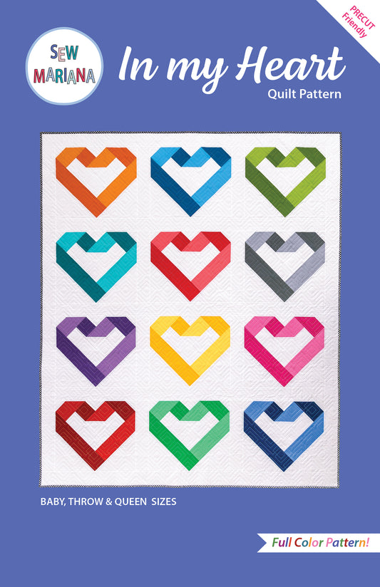 cover of the in my heart quilt pattern with an image of the throw size quilt in rainbow colors